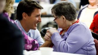 PM Trudeau shakes hands with a resident