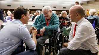 PM Trudeau and MP Fillmore kneel and speak to a resident