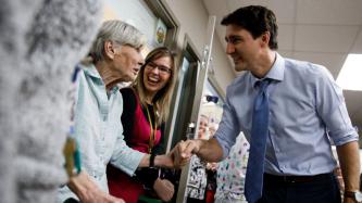 PM Trudeau shakes hands with an elderly woman
