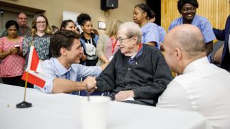 PM Trudeau shakes hand with a resident
