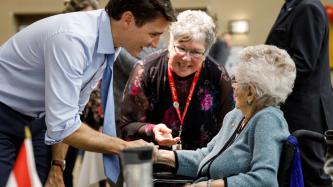 PM Trudeau shakes hands with a resident