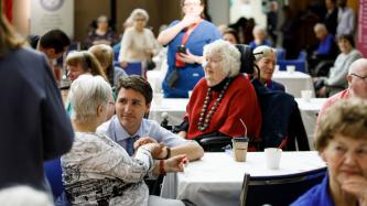 PM Trudeau shakes hands with a resident