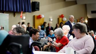 PM Trudeau shakes hands with a resident
