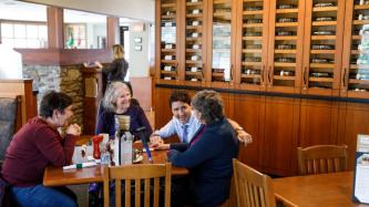 Le PM Trudeau, agenouillé, parle avec un groupe de femmes 