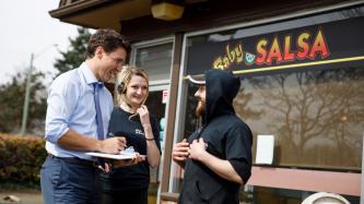 Le PM Trudeau parle avec deux employés devant le restaurant Baby Salsa