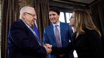 President Rivlin shakes hands with Minister Freeland while PM Trudeau looks on