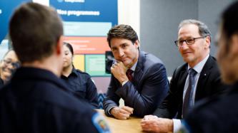 PM Trudeau listens to someone speak during a meeting