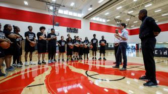 PM Trudeau speaks to youth while Minister Hussen and Raptors President Masai Ujiri look on