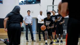 PM Trudeau and Min. Hussen watch youth take part in a basketball drill