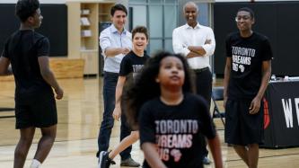 PM Trudeau watches his son take part in a drill, while Min. Hussen looks on