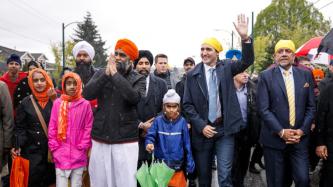 Le PM Trudeau et le ministre Sajjan marchent avec un groupe de gens dans le défilé de Vaisakhi