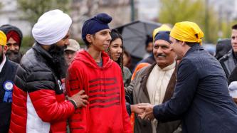 Le PM Trudeau serre la main d’une femme sous le regard d’autres personnes
