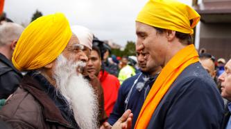 Un homme et le PM Trudeau échangent un sourire