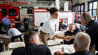 PM Trudeau shakes hands with a first responder