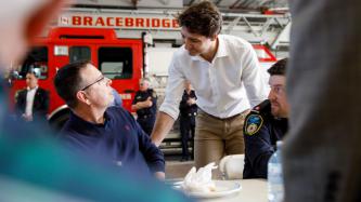 PM Trudeau leans over and speaks to a man