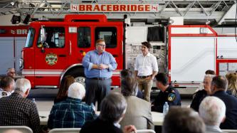 Bracebridge Mayor Smith speaks to a group of first responders beside PM Trudeau