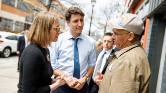 Minister Gould and PM Trudeau speak to a man 