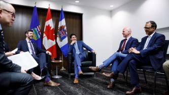 PM Trudeau and attendees laugh in the meeting