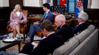 PM Trudeau, President Kolinda Grabar-Kitarović, and attendees sit in the meeting