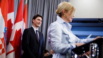 President Kolinda Grabar-Kitarović speaks at the podium beside PM Trudeau