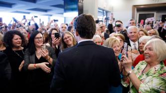 PM Trudeau stands in front of a group of women