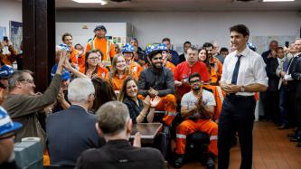 PM Trudeau stands in a room filled with steel workers