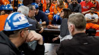 Photo of a room filled with steel workers