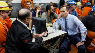 Minister Morneau listens as someone speaks to him