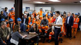 PM Trudeau stands in a room filled with steel workers 