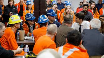 Steel workers listen as PM Trudeau speaks to those sitting around him