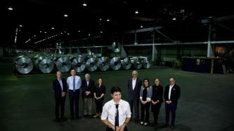 PM Trudeau stands at a microphone inside a steel plant