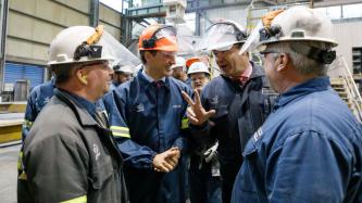 Le PM Trudeau sourit à côté d’employés de l’Aluminerie Alouette