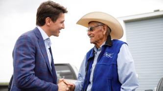 PM Trudeau shakes hands with an elderly man