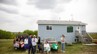 PM Trudeau speaks to a family in front of a home
