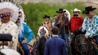 A group of men on horseback photograph PM Trudeau
