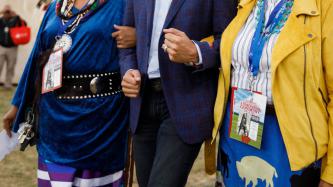 PM Trudeau walks arm in arm with two women