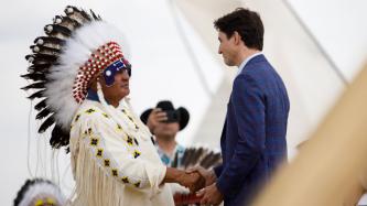 PM Trudeau shakes hands with Chief Antoine in a headdress