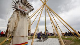 PM Trudeau kneels beside the grave of Chief Poundmaker