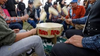 Ceremony attendees take part in a drum circle