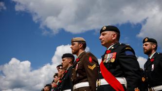 Canadian soldiers stand at attention