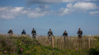 Canadian soldiers stand behind fence