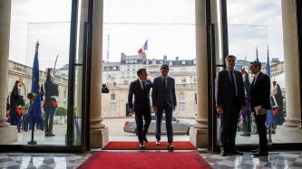 President Macron and PM Trudeau walk in the Palais de l’Élysée