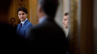 PM Trudeau looks at President Macron talking
