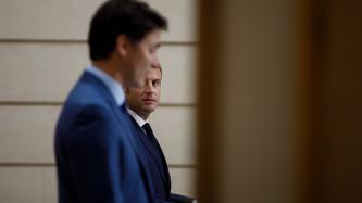 President Macron looks at PM Trudeau talking