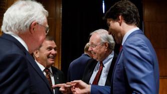 PM Trudeau speaks with Paul Martin and two other men