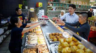 PM Trudeau shares a laugh with others at the service counter