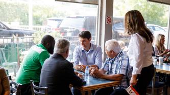 PM Trudeau sits at a table with customers
