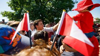 PM Trudeau reaches for a child in a crowd