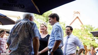 PM Trudeau talks with others on an outdoor patio