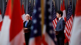 VP Pence speaks at the podium beside PM Trudeau